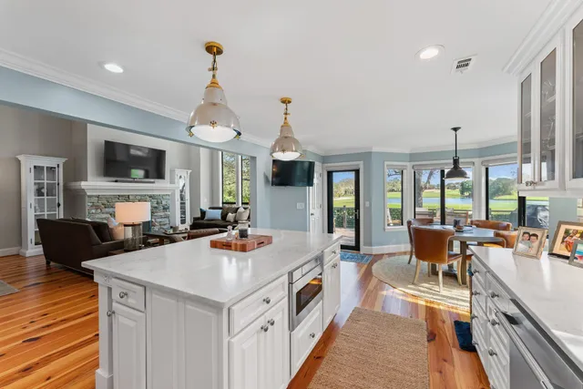 a kitchen with stainless steel appliances granite countertop a stove refrigerator and a dining table with wooden floor