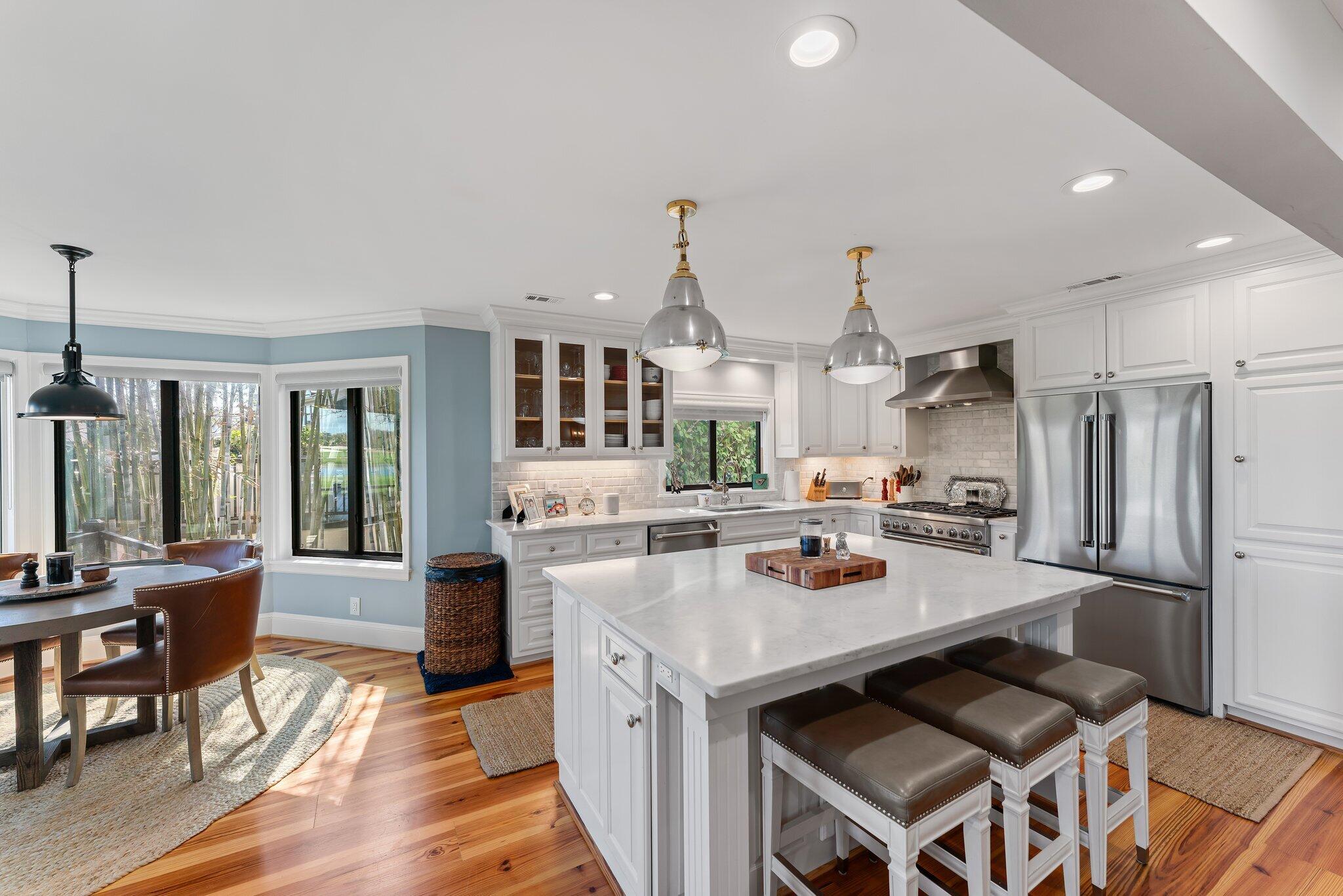 18760 Southeast Pineneedle Lane Jupiter, FL 33469 - Photo 21 of 58 a kitchen with stainless steel appliances granite countertop a stove refrigerator and a dining table with wooden floor