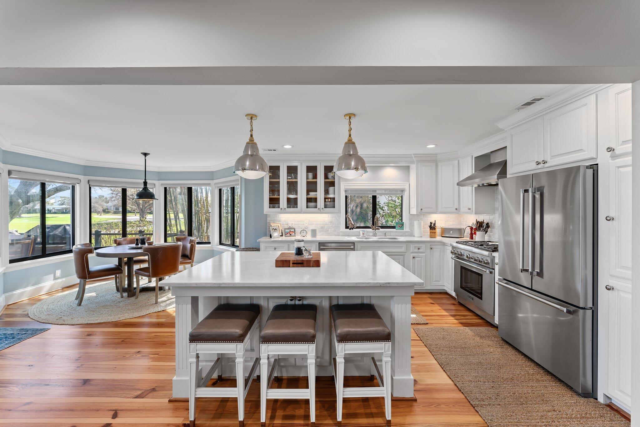 18760 Southeast Pineneedle Lane Jupiter, FL 33469 - Photo 22 of 58 a large white kitchen with a table and chairs in it