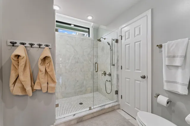 a bathroom with a granite countertop sink toilet a large mirror a shower and a bathtub