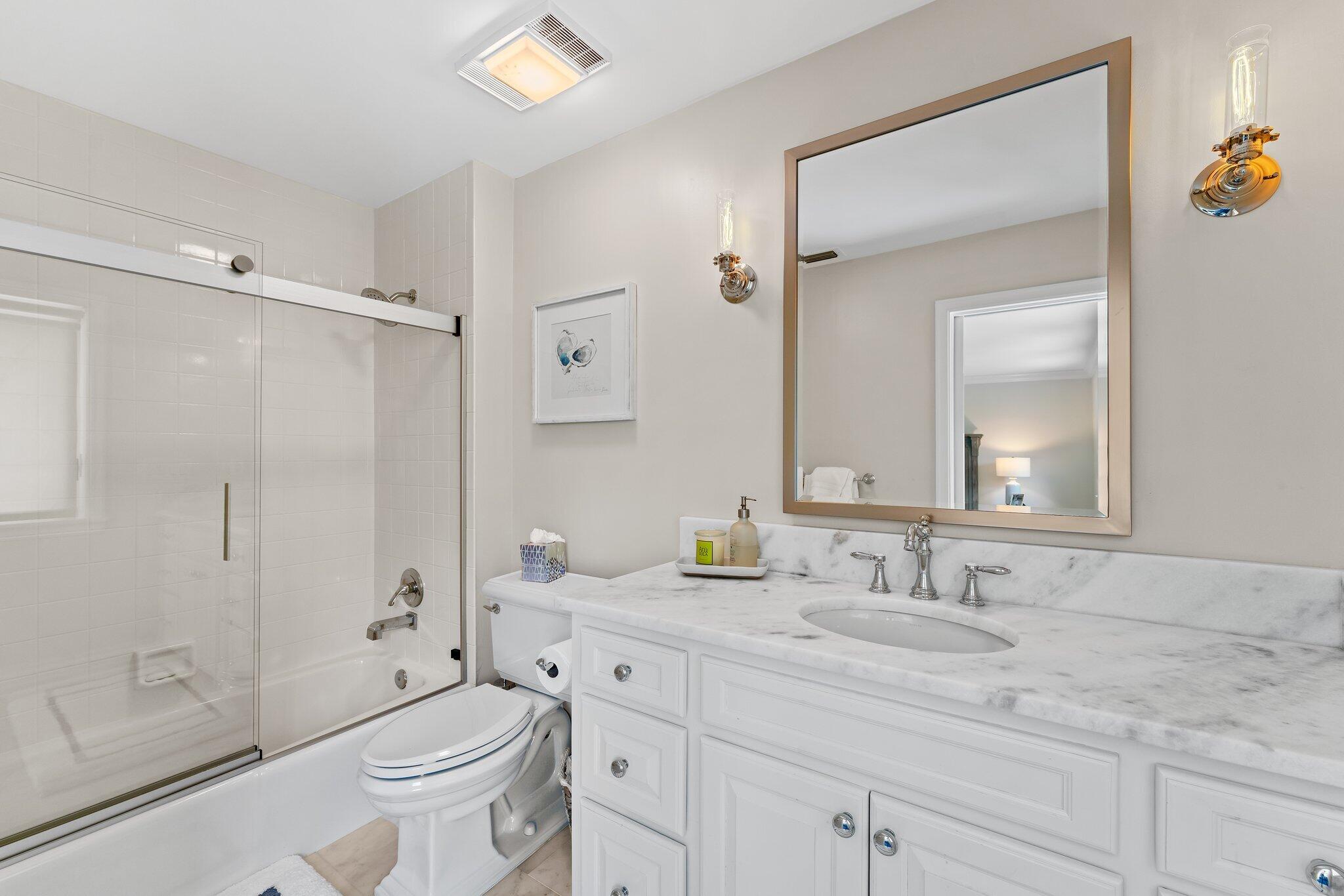 18760 Southeast Pineneedle Lane Jupiter, FL 33469 - Photo 38 of 58 a bathroom with a granite countertop sink toilet a large mirror a shower and a bathtub