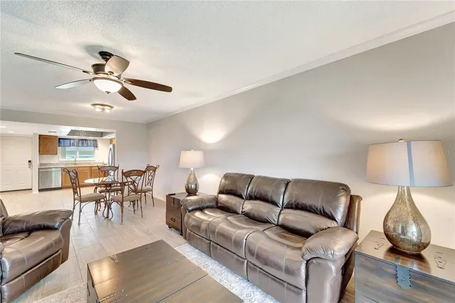 a living room with furniture a dining table and a chandelier