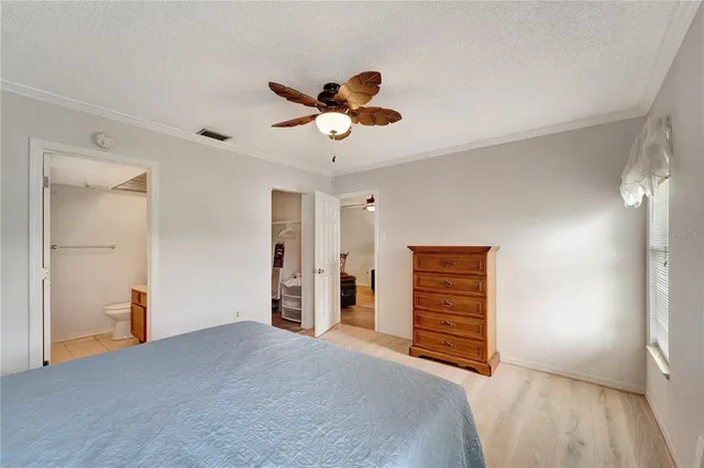 a room that has a bed and a chandelier fan