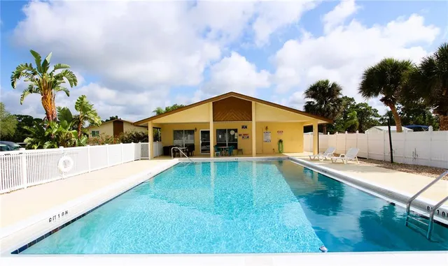 a view of a house with swimming pool and sitting area