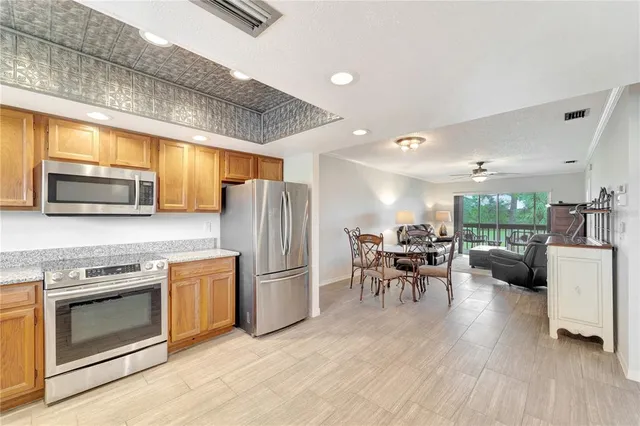 a kitchen with refrigerator a stove and chairs