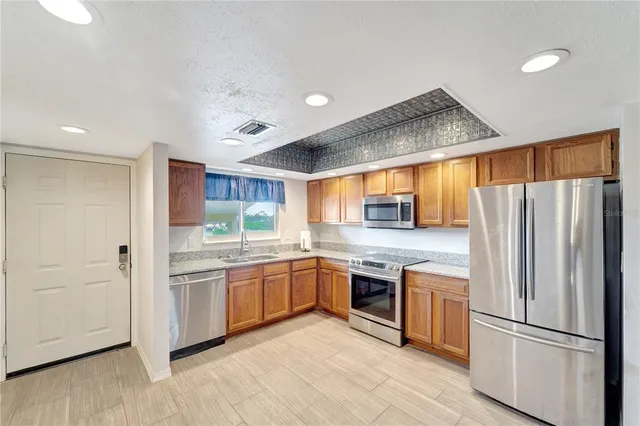 a kitchen with stainless steel appliances granite countertop a refrigerator and a stove top oven