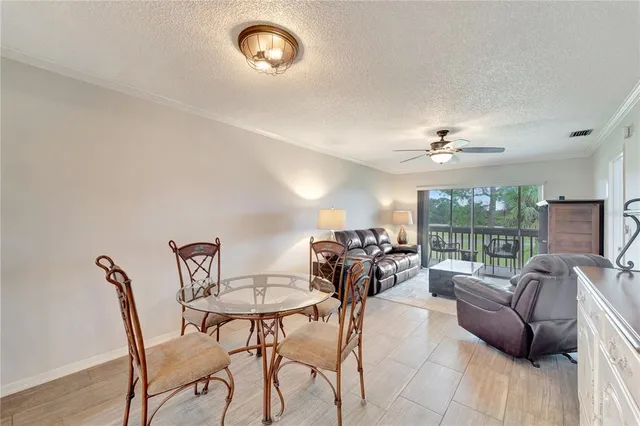 a view of a livingroom and a dining room with furniture wooden floor and a rug