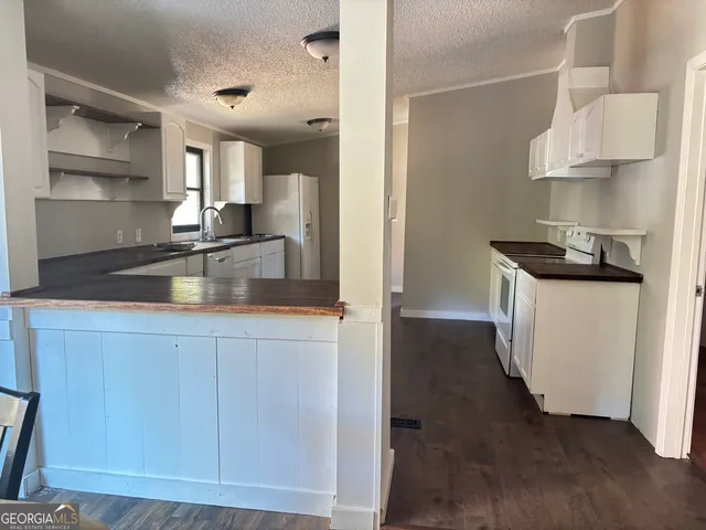 a kitchen with kitchen island granite countertop a sink and a stove
