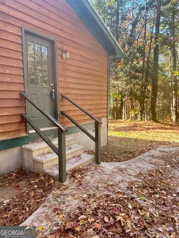 a view of a house with backyard and trees