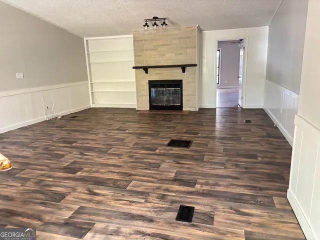 a view of empty room with fireplace and wooden floor