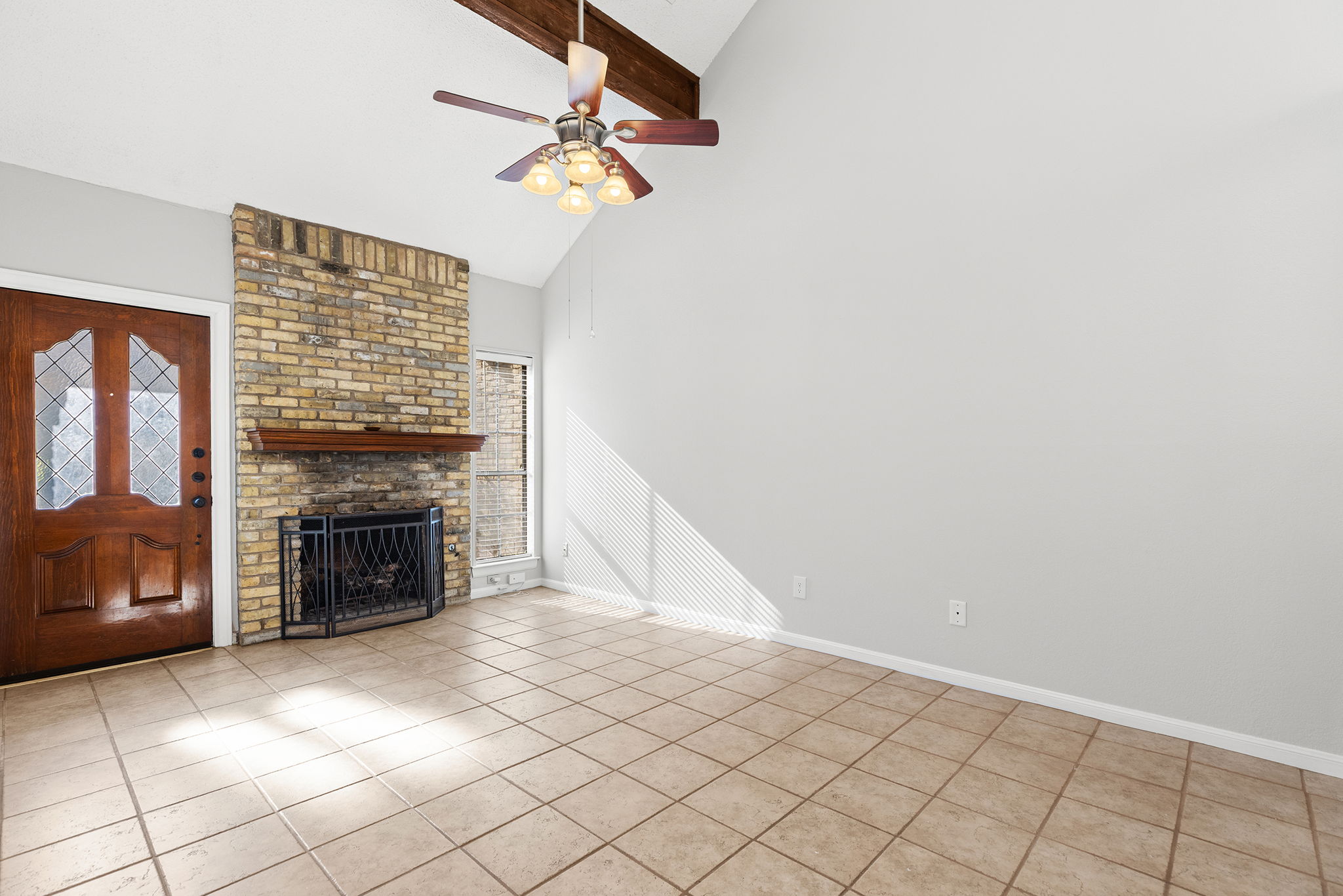 10819 Crown Colony Drive, Unit 11 Austin, TX 78747 - Photo 9 of 40 The living room immediately draws you in with its vaulted ceilings and the warmth of a brick fireplace that anchors the space.