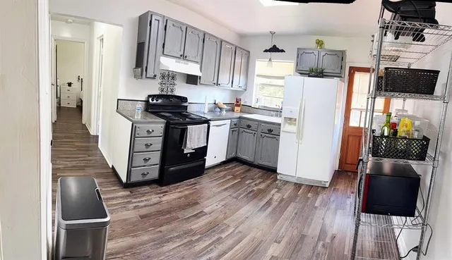 a kitchen with stainless steel appliances a refrigerator stove and wooden floor