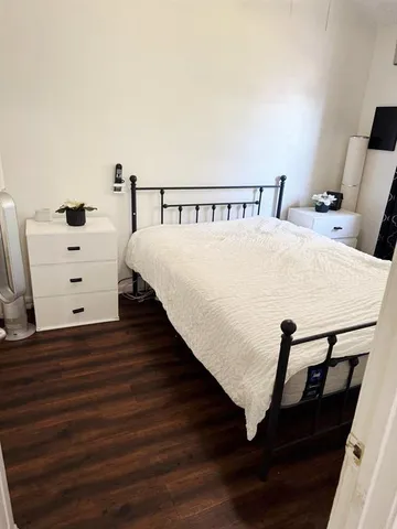 a bed sitting in a bedroom next to a window with dresser