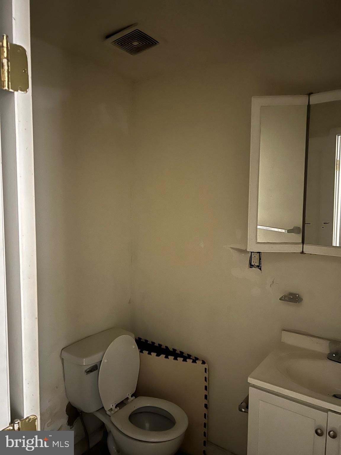 449 Baltimore Avenue Cumberland, MD 21502 - Photo 16 of 22 a bathroom with a toilet a sink and a mirror