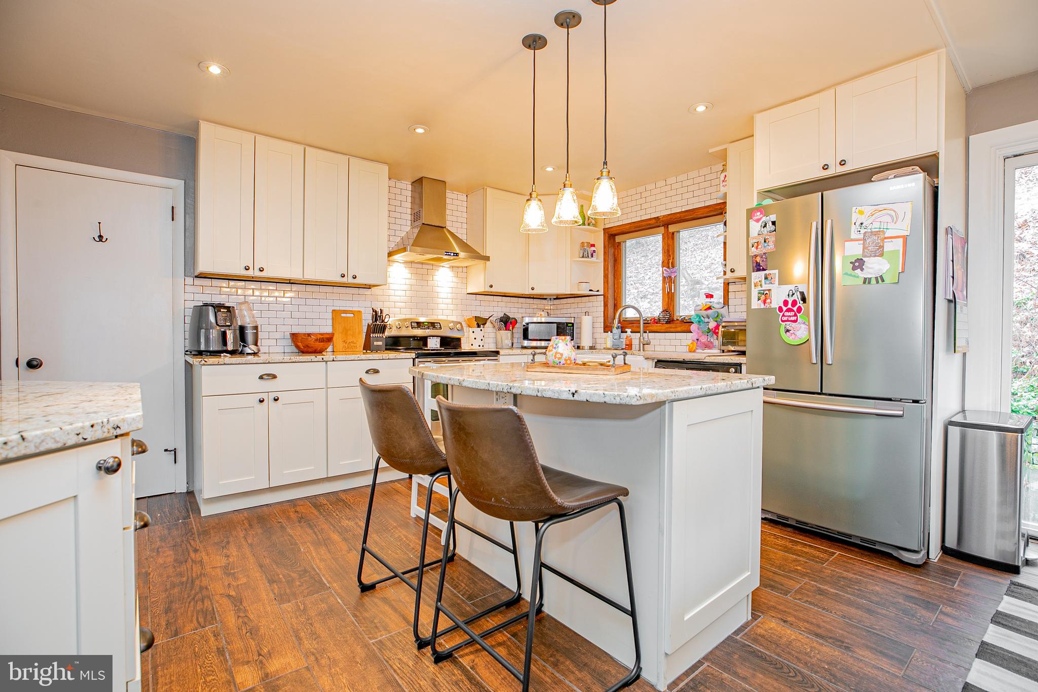 611 Brookwood Road Wayne, PA 19087 - Photo 8 of 41 a kitchen with a sink a refrigerator a stove and white cabinets with wooden floor