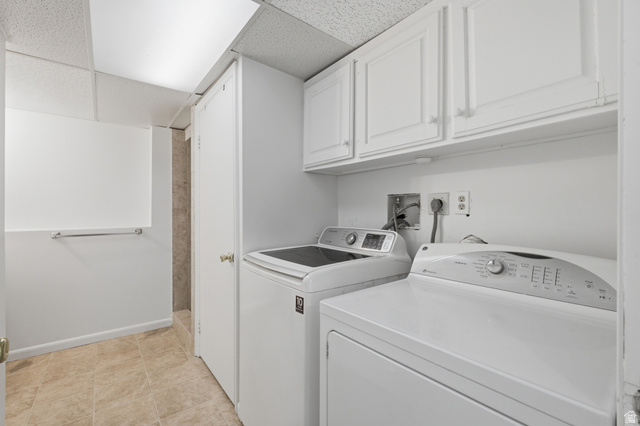 7910 Woolley Way Magna, UT 84044 - Photo 19 of 26 Dedicated laundry area featuring a washer and dryer, white cabinetry, and a tile floor