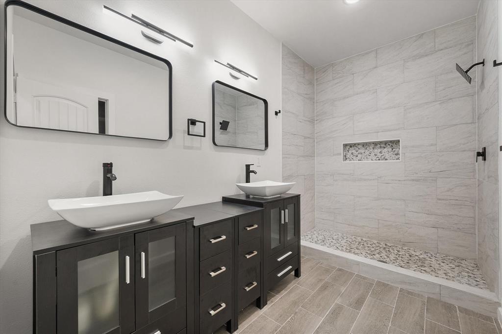 6771 Northwest County Road 1146 Barry, TX 75102 - Photo 4 of 34 a bathroom with a granite countertop sink a mirror and shower
