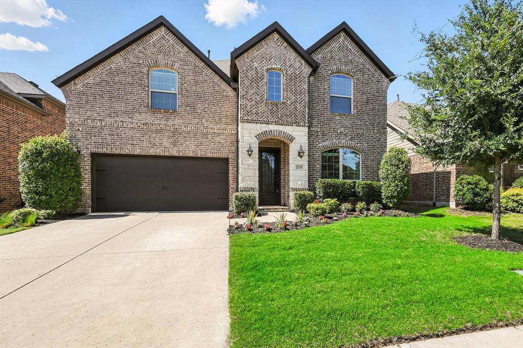 a front view of a house with a yard and garage