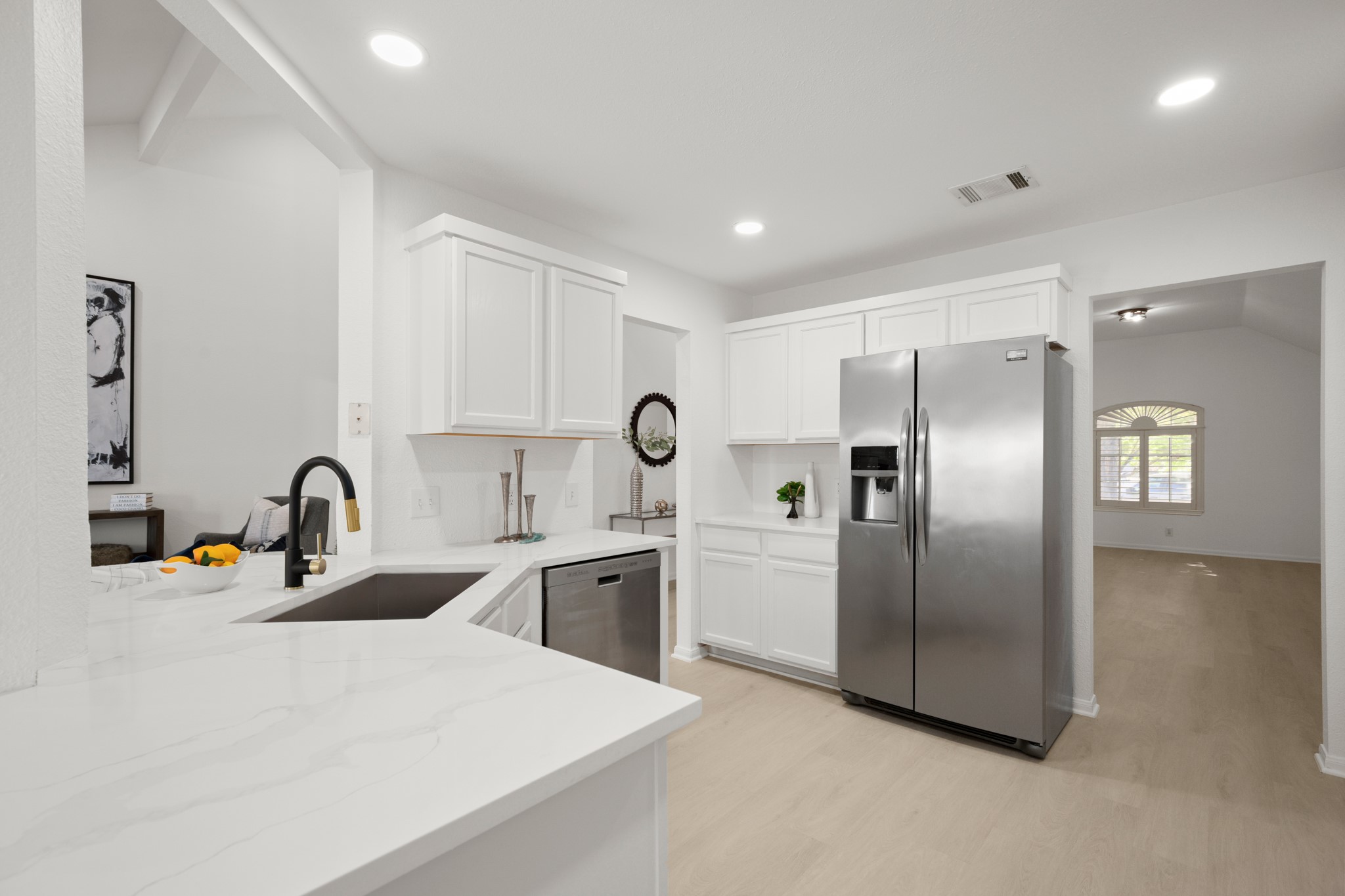 310 Bailey Loop Kyle, TX 78640 - Photo 13 of 30 Kitchen featuring stainless steel appliances, white cabinets, light stone countertops, light wood-type flooring, and recessed lighting