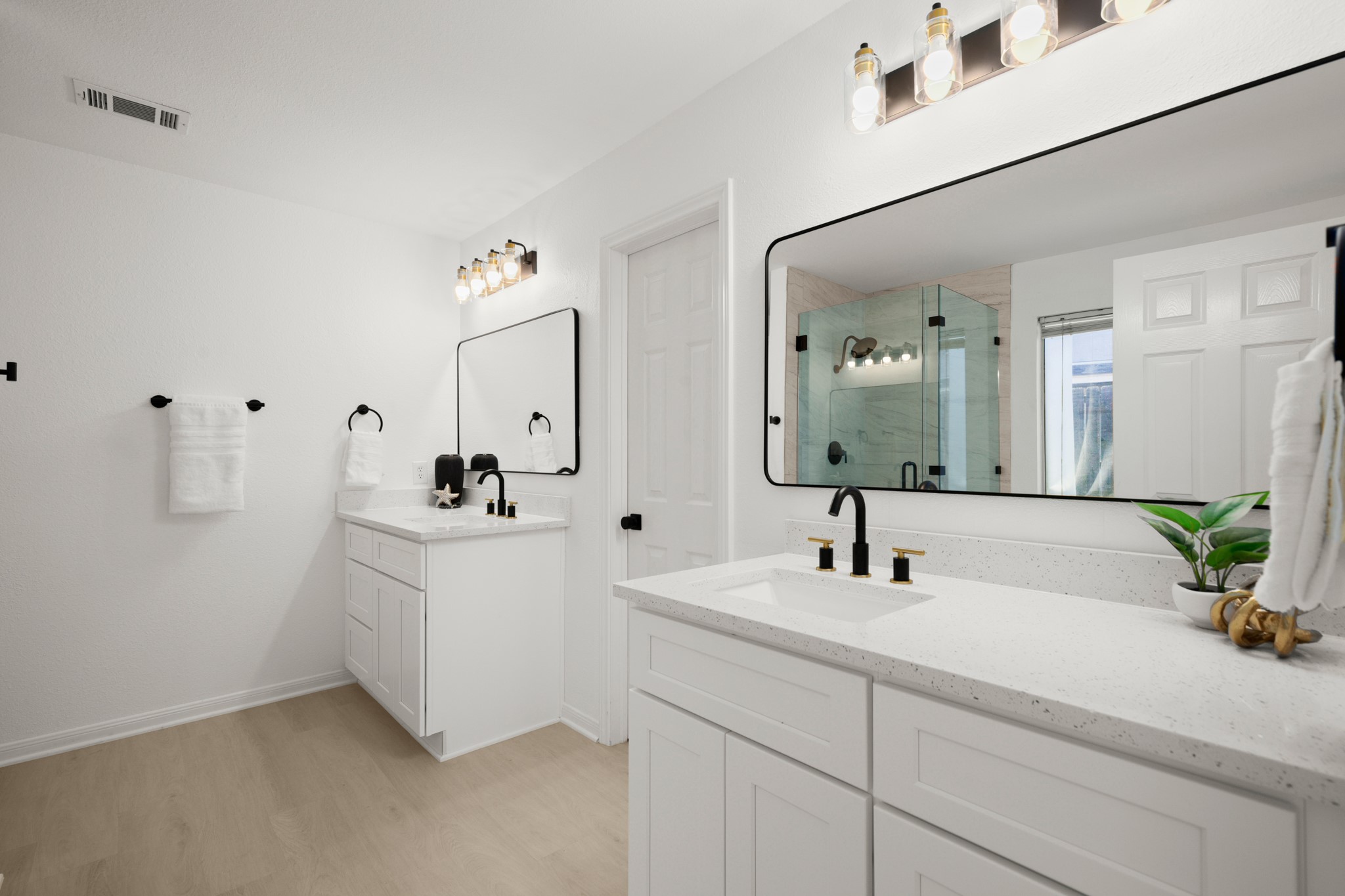 310 Bailey Loop Kyle, TX 78640 - Photo 19 of 30 Full bath with two vanities, a marble finish shower, and light wood-style flooring