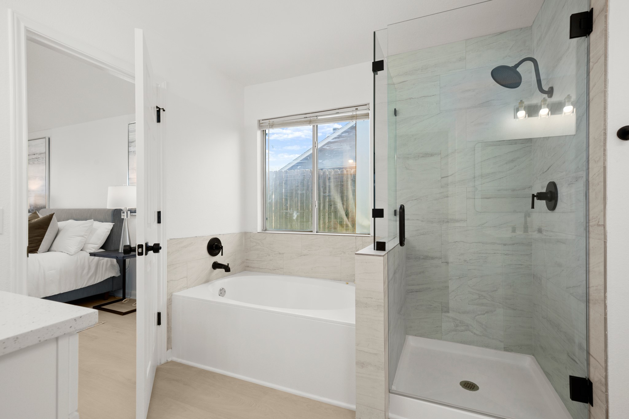 310 Bailey Loop Kyle, TX 78640 - Photo 20 of 30 Full bathroom featuring connected bathroom, vanity, a bath, a marble finish shower, and light wood finished floors