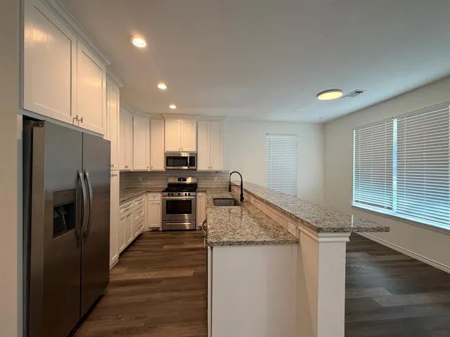 a kitchen with a refrigerator sink and cabinets