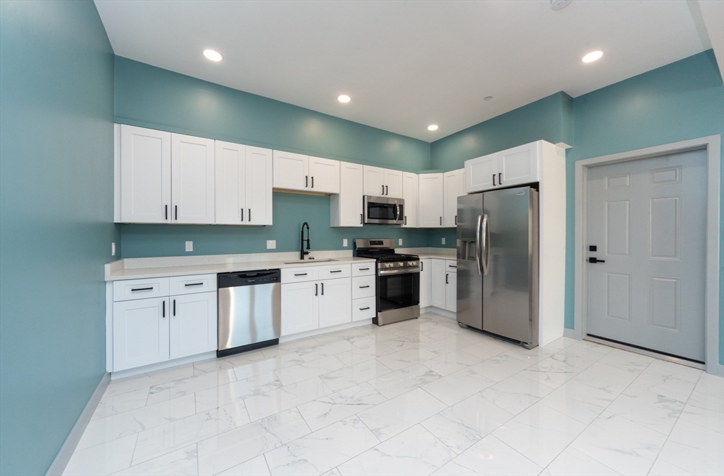 115-117 Mechanic Street, Unit 3 Clinton, MA 01510 - Photo 3 of 17 a kitchen with granite countertop white cabinets and stainless steel appliances