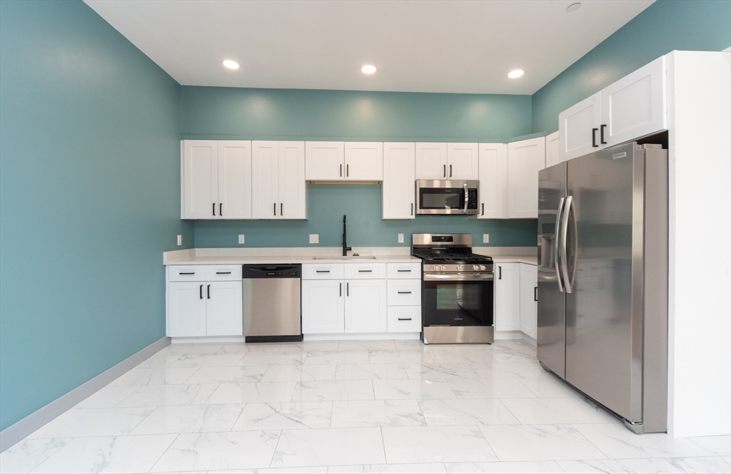 115-117 Mechanic Street, Unit 3 Clinton, MA 01510 - Photo 4 of 17 a kitchen with a stove a refrigerator and a sink