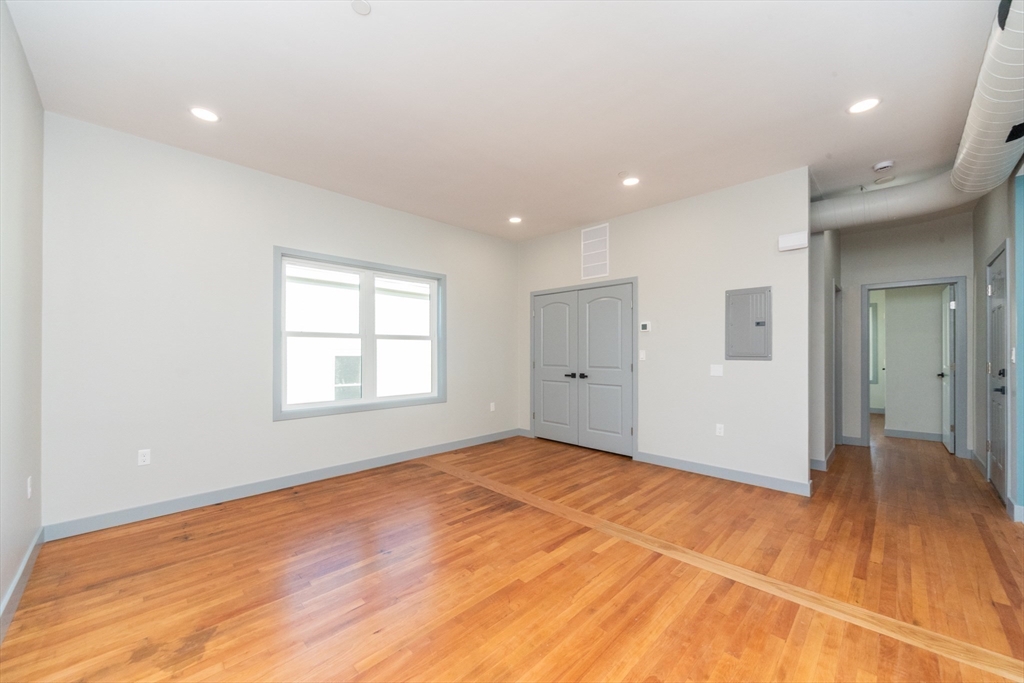 115-117 Mechanic Street, Unit 3 Clinton, MA 01510 - Photo 5 of 17 a view of an empty room with wooden floor and a window