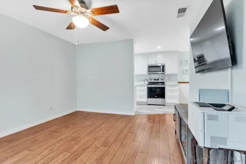 a living room with furniture and a wooden floor