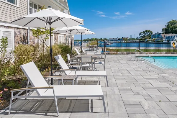 a view of a swimming pool with a table and chairs under an umbrella