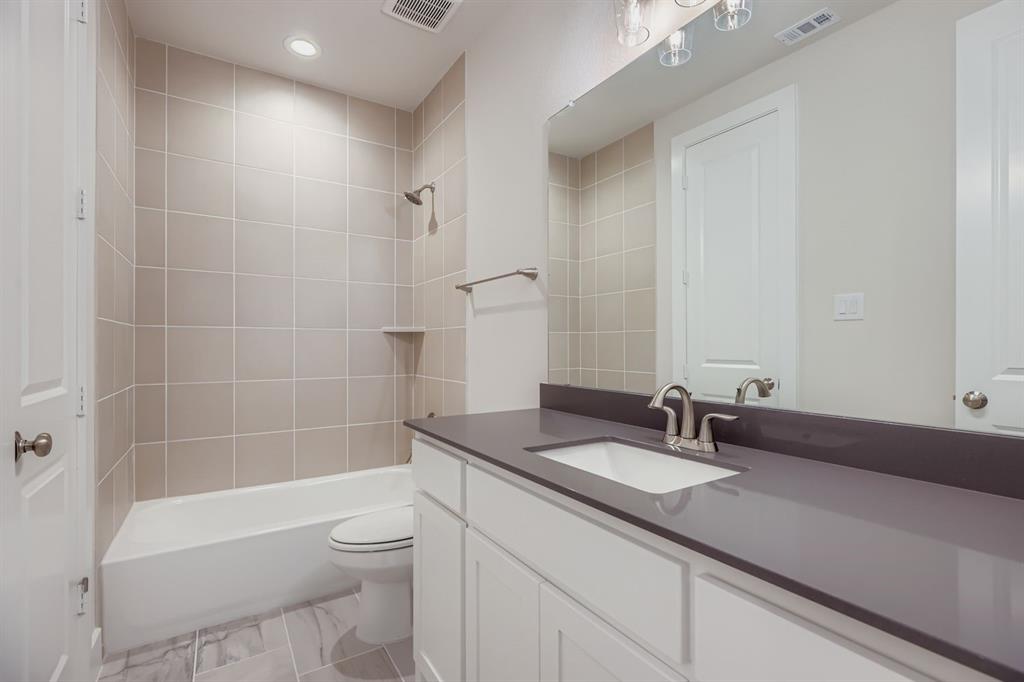 4203 Windy Point Court Oak Point, TX 75068 - Photo 18 of 29 a bathroom with a granite countertop sink a toilet and bathtub