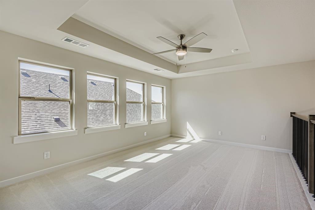 4203 Windy Point Court Oak Point, TX 75068 - Photo 23 of 29 a view of an empty room with a window and a ceiling fan