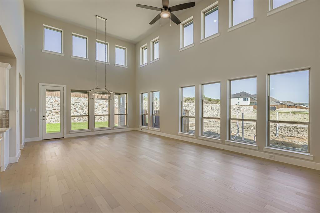 4203 Windy Point Court Oak Point, TX 75068 - Photo 5 of 29 a view of an empty room with a large window and wooden floor