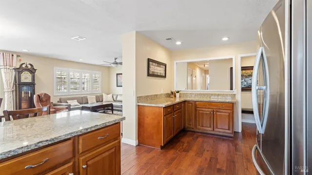 a kitchen with stainless steel appliances granite countertop a refrigerator a sink and wooden cabinets
