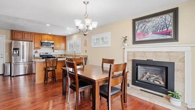 a living room with fireplace a flat screen tv and kitchen view