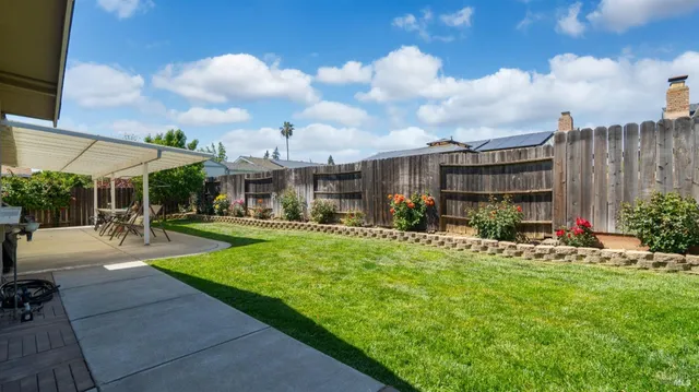 a view of a patio with a table and chairs and potted plants