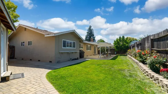 a view of a house with backyard sitting area and garden