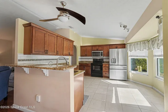 a kitchen with a refrigerator and a stove top oven