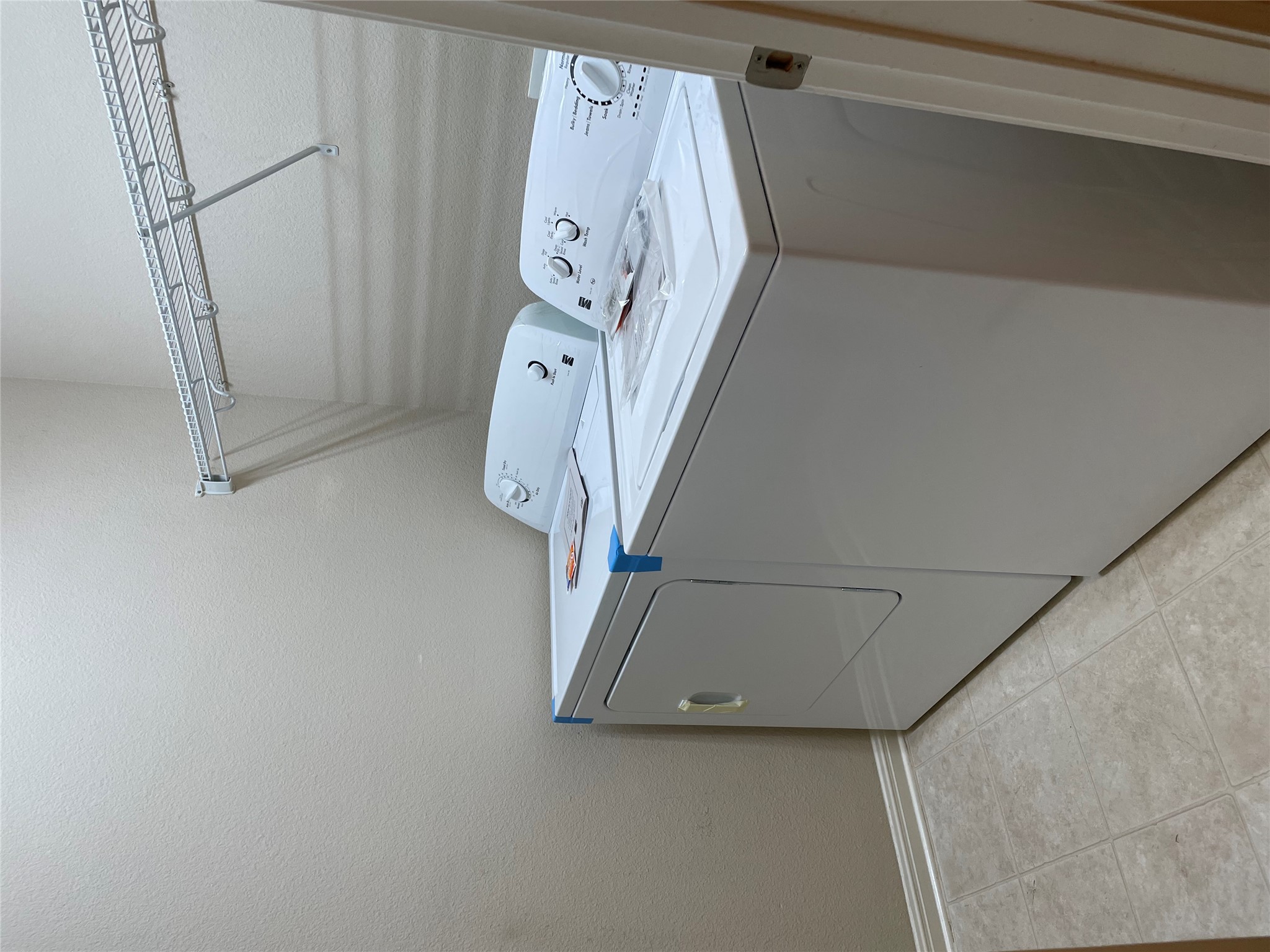 11713 Dunblane Way Austin, TX 78754 - Photo 21 of 22 Dedicated laundry area featuring a washer and dryer, tile flooring, wire shelving, and neutral wall paint