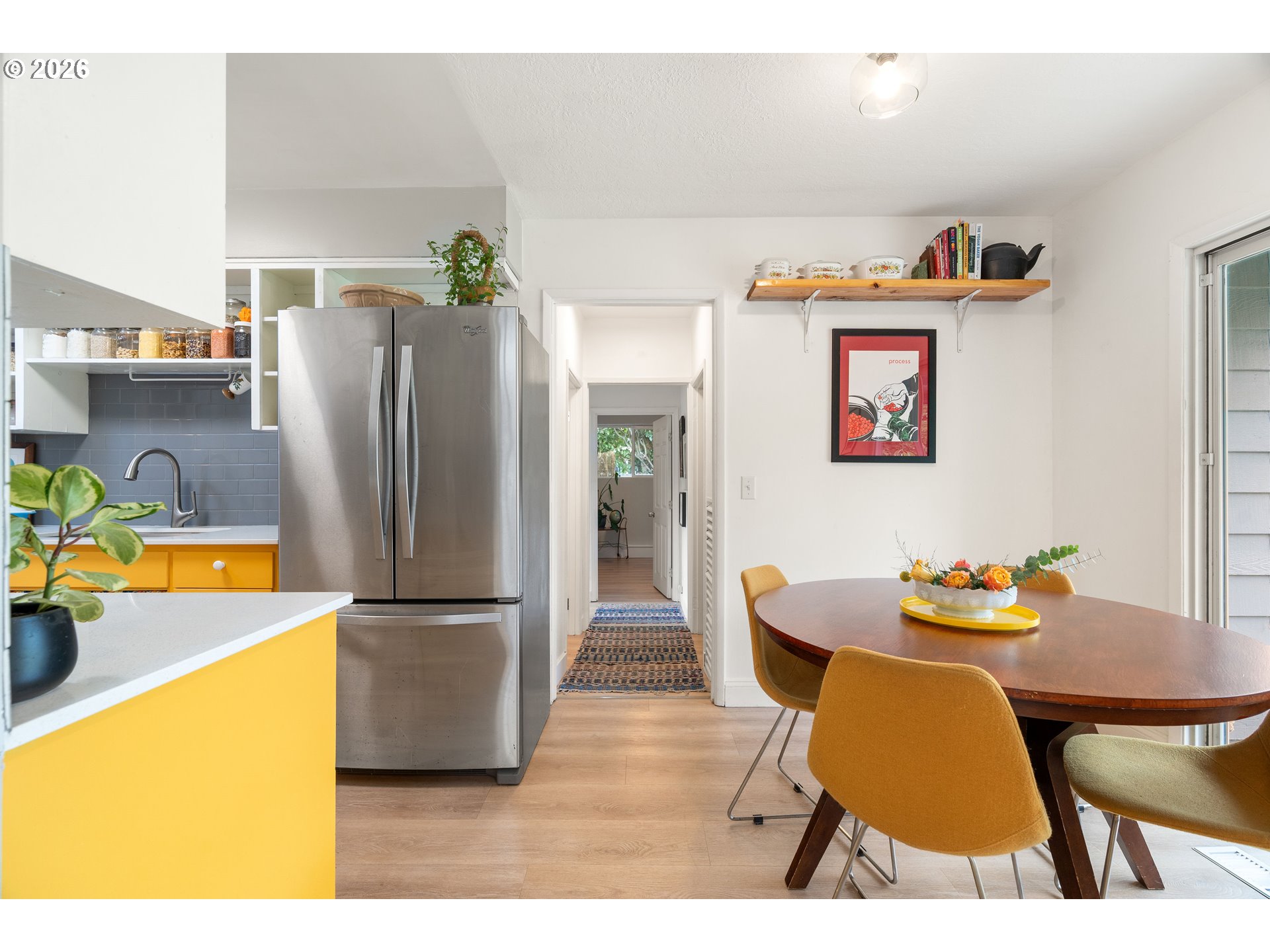 3835 North Alaska Street Portland, OR 97217 - Photo 17 of 43 a dining room with stainless steel appliances kitchen island granite countertop a refrigerator a stove and a dining table with wooden floor