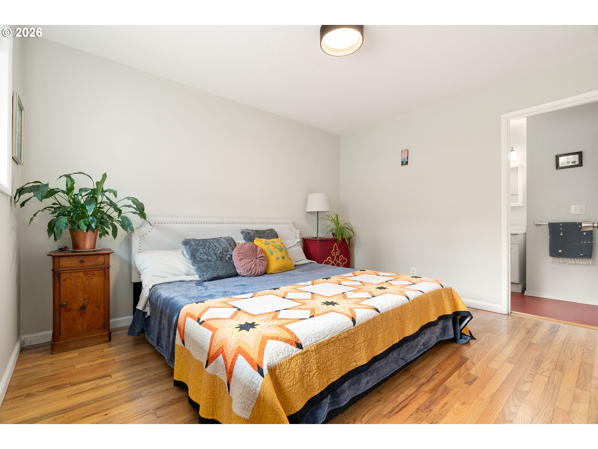 3835 North Alaska Street Portland, OR 97217 - Photo 19 of 43 a bedroom with a bed and a potted plant
