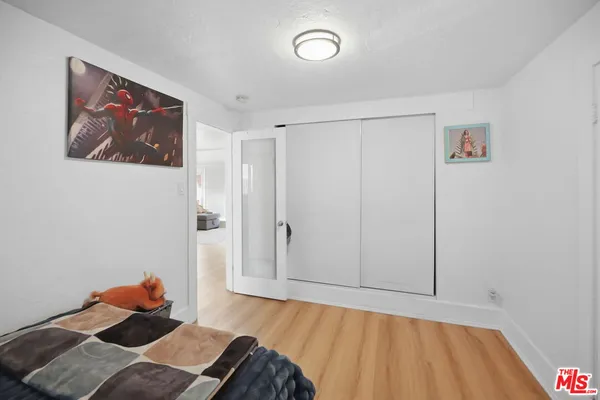 a bedroom with a bed and a painting on the wall
