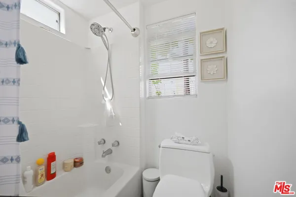 a bathroom with a bathtub shower sink vanity and toilet