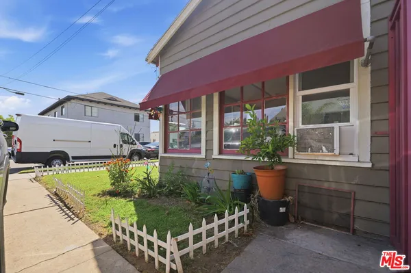 a view of house with a yard and sitting area
