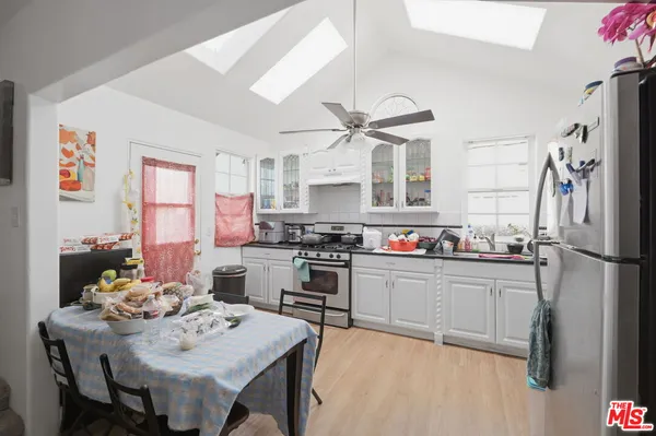a kitchen with a refrigerator a stove a dining table and chairs