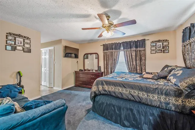 a bedroom with a large bed and a chandelier