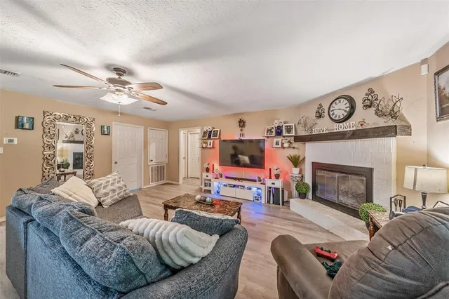 a living room with furniture a fireplace and a flat screen tv