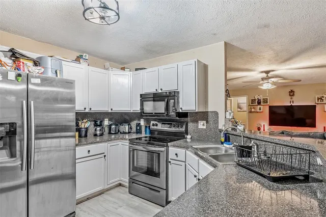 a kitchen with stainless steel appliances a refrigerator a stove a sink and a microwave