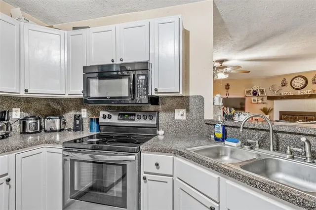 a kitchen with granite countertop a sink stainless steel appliances and cabinets